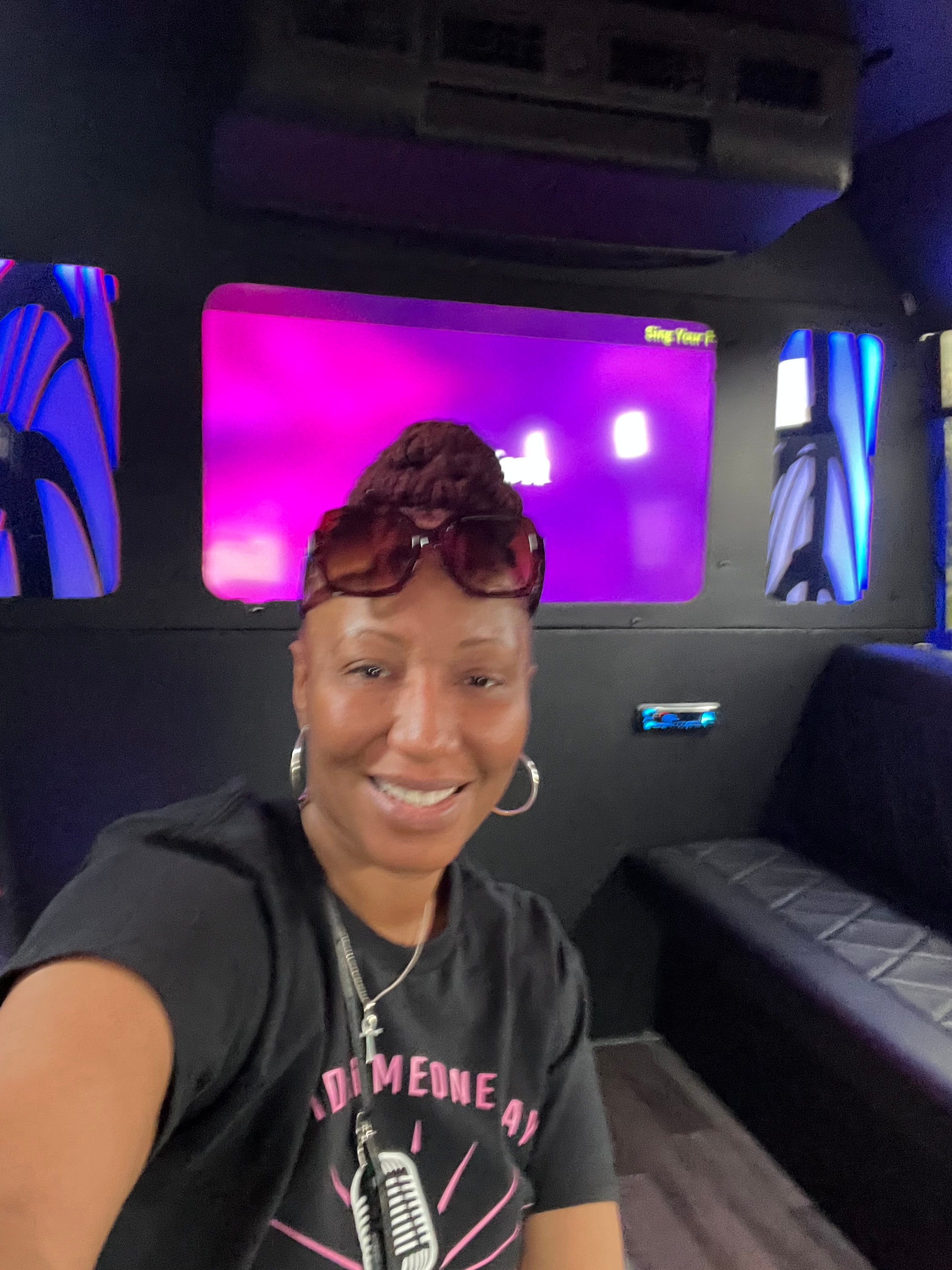 Barbara selfie inside the karaoke bus with purple screen glow