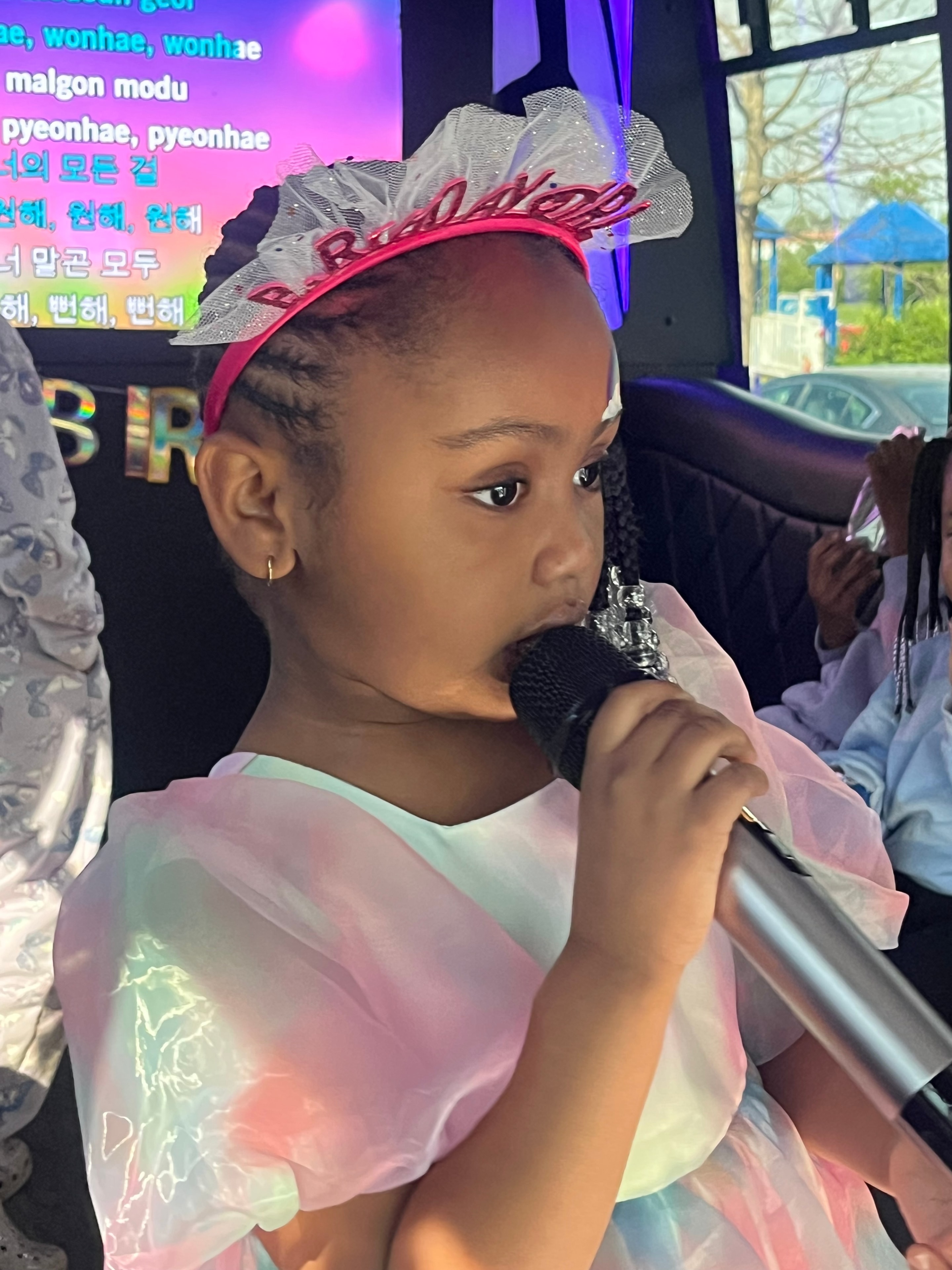 Birthday girl singing into microphone on the bus
