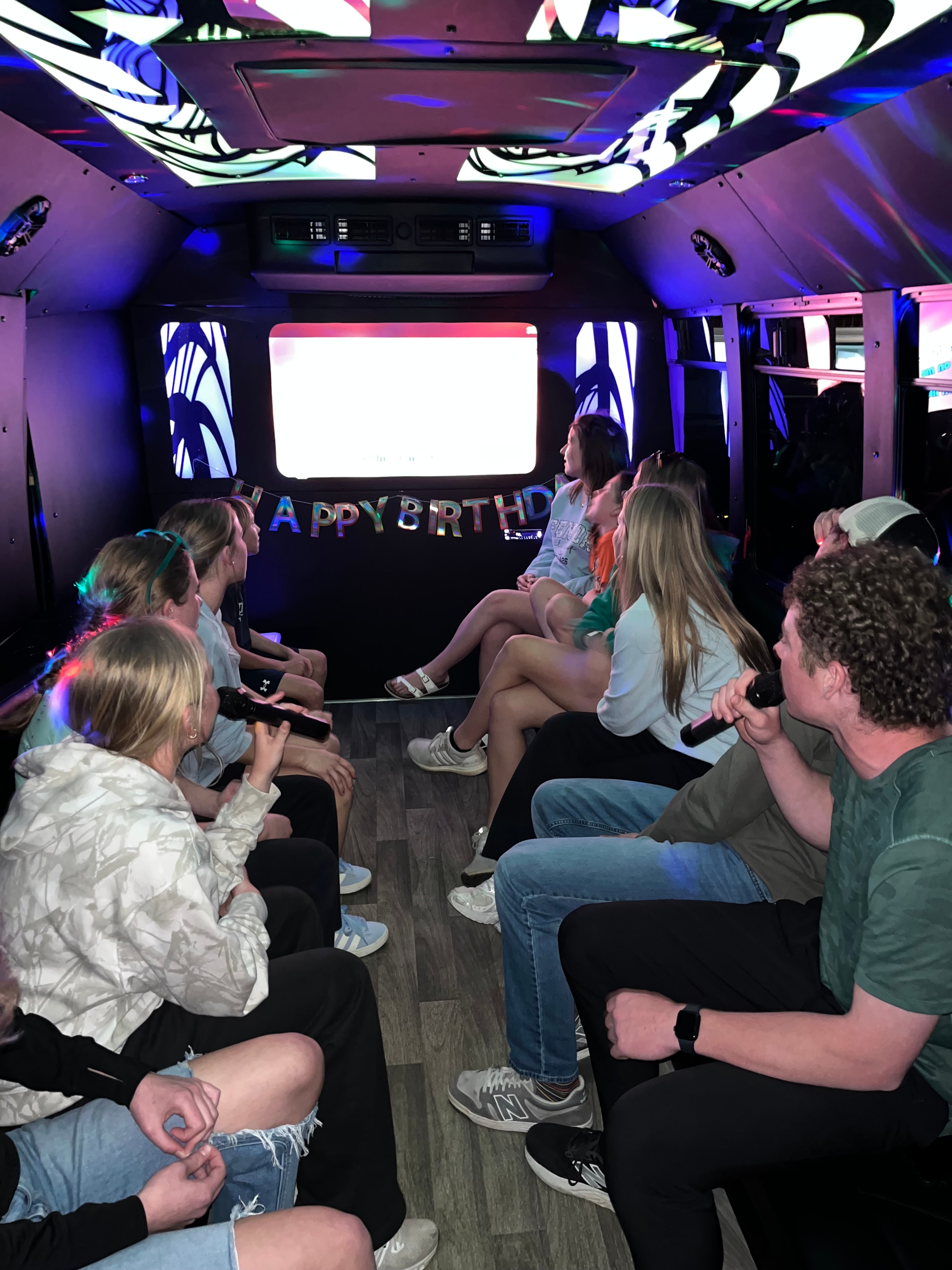 Group singing together on the karaoke bus