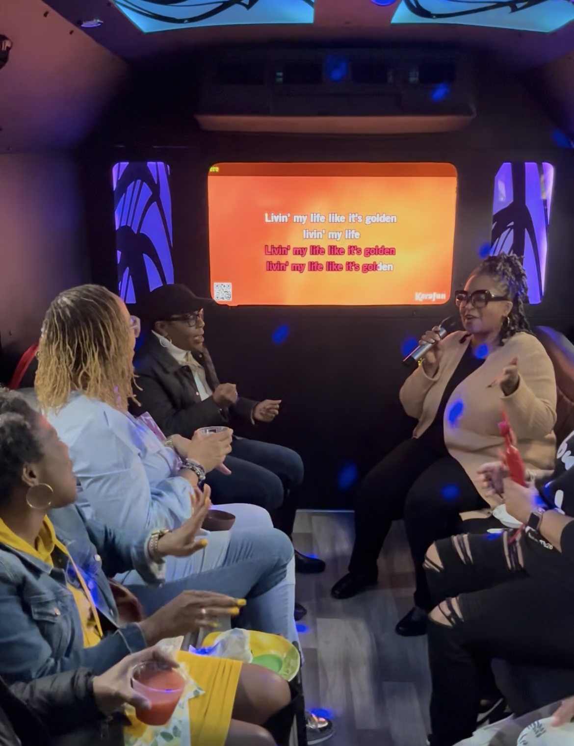 People engaged in lively conversation in a cozy room with warm lighting.