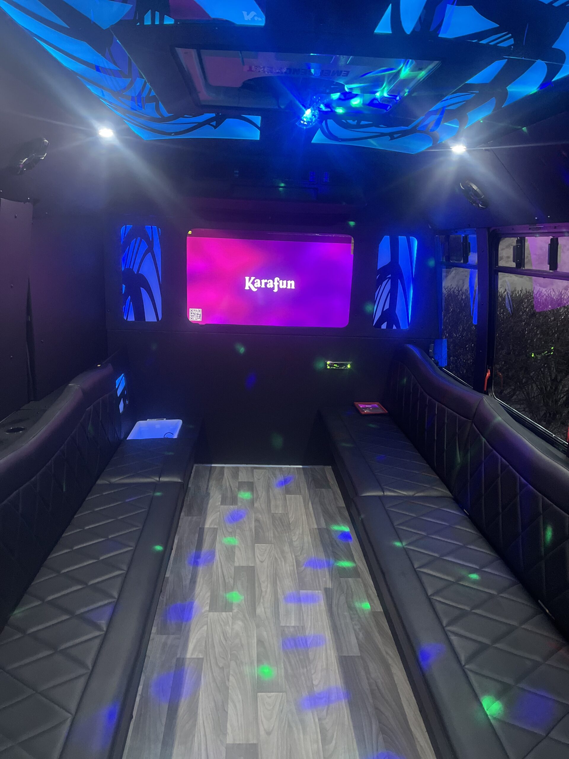 Karaoke room with plush seating and vibrant lighting.