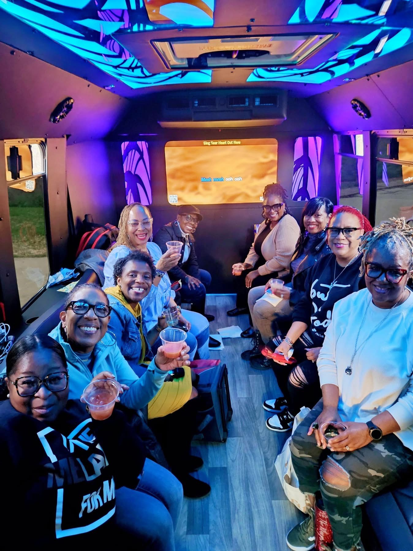 A group of friends enjoying a fun ride inside a party bus with vibrant lighting.